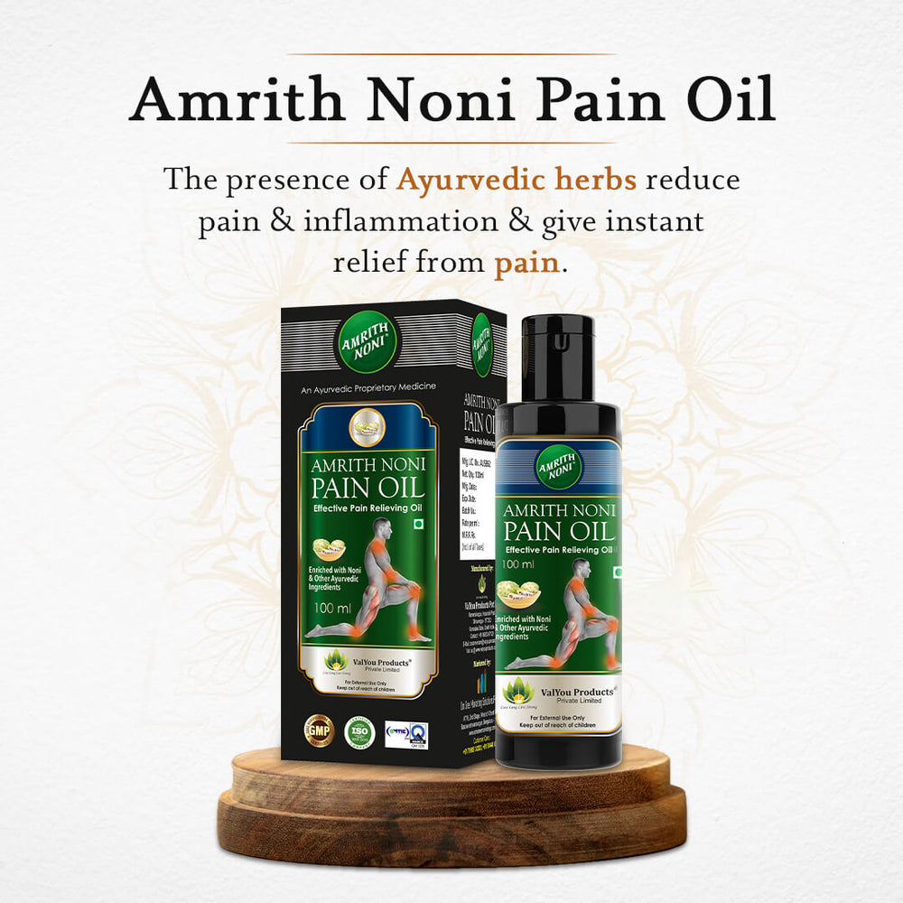 
                  
                    Amrith Noni Pain Oil packaging on a wooden stand with text about Ayurvedic herbs.
                  
                